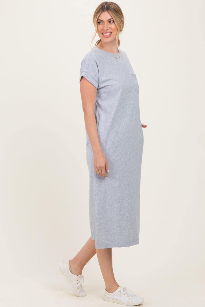 woman wearing a gray short sleeve midi dress with a pocket and side slits, styled with white sneakers