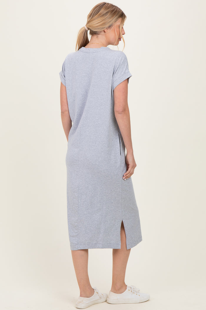 woman wearing a gray short sleeve midi dress with side slits and a relaxed fit, viewed from the back