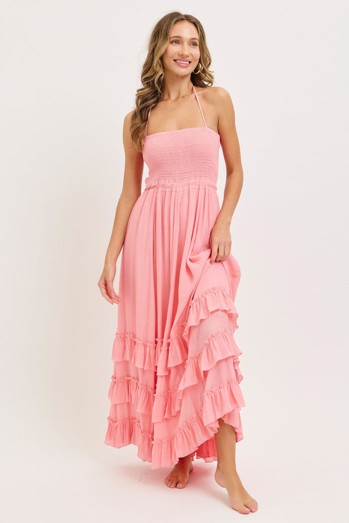 woman wearing a pink strapless maxi dress with tiered ruffles and a smocked bodice