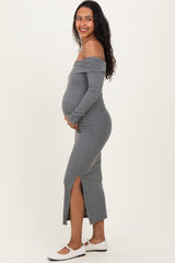 woman wearing a gray off-the-shoulder maternity dress with a side slit, showcasing her baby bump