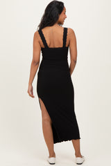 woman wearing a black maternity maxi dress with lace-trimmed straps and a side slit, showing her back