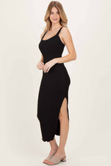 woman wearing a black sleeveless maxi dress with lace detailing and side slit, styled with gray slide-on sandals