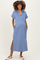 woman wearing a light blue maternity dress with a collared neckline and side pockets, showing off her baby bump