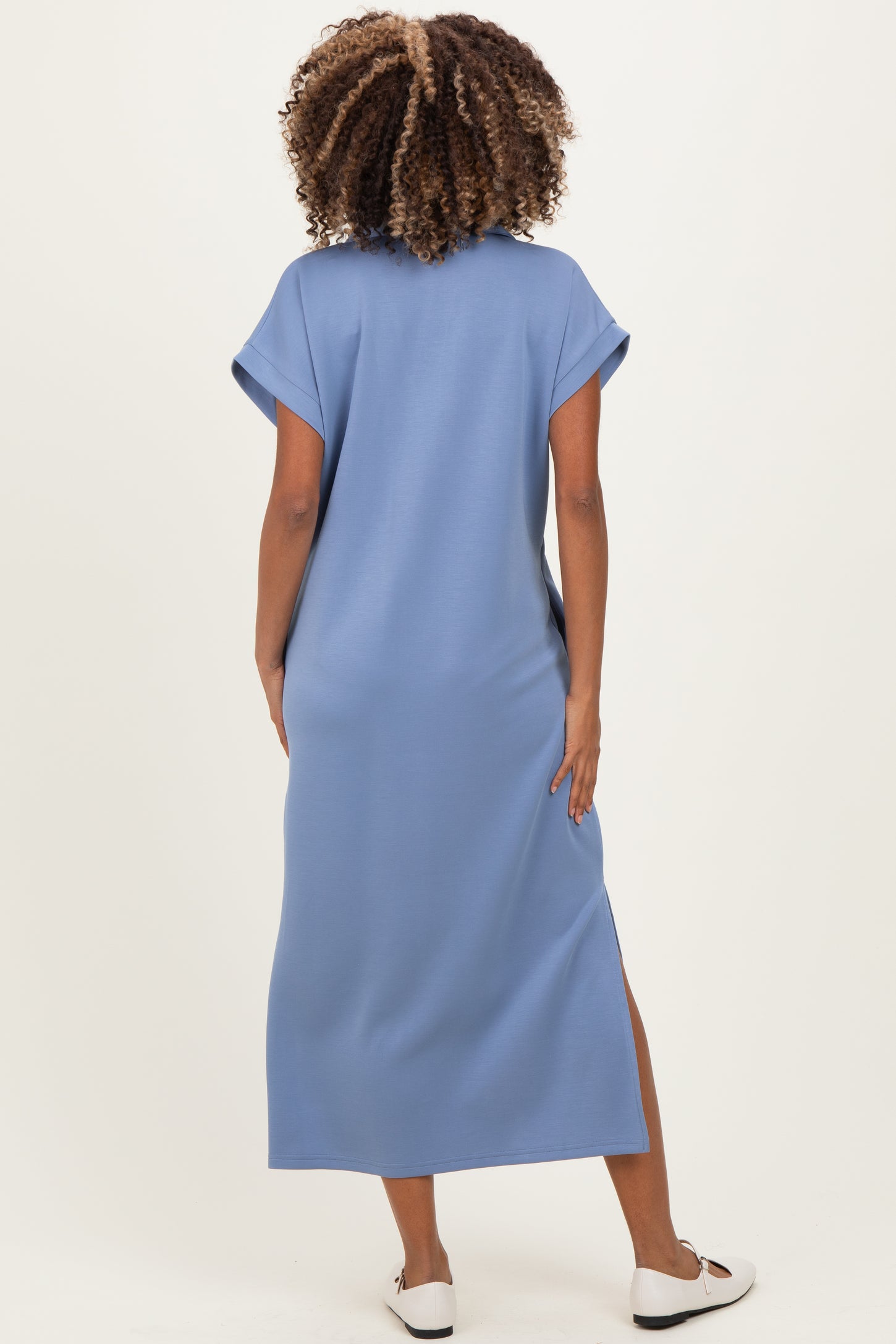 woman wearing a blue maternity maxi dress with short sleeves and side slits, shown from the back