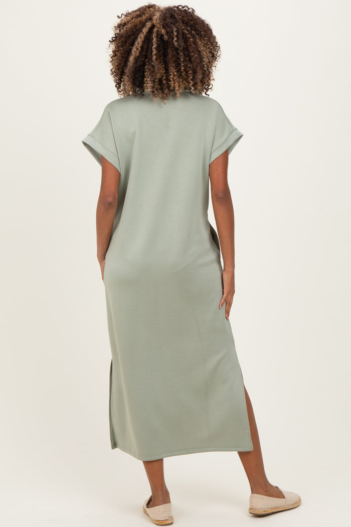 woman wearing a green maternity maxi dress with short sleeves and side slits, showing her back