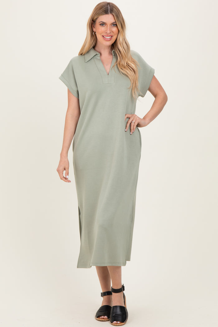 woman wearing a sage green collared maxi dress with short sleeves and side slits, standing and smiling