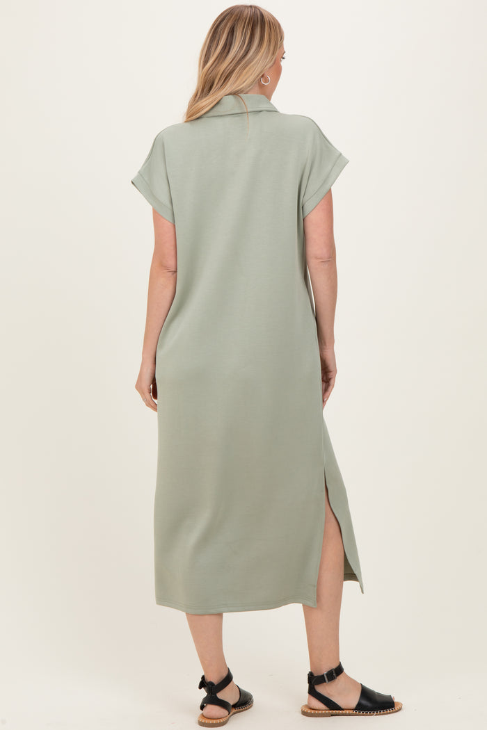 woman wearing a sage green short sleeve midi dress with side slits and a relaxed fit