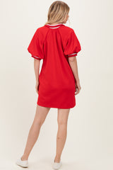 woman wearing a red short sleeve dress with puffed sleeves and a relaxed fit, shown from the back