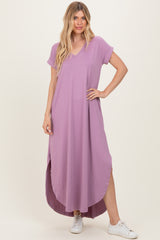 woman wearing a lavender short sleeve maxi dress with a high-low hem and side slits, paired with white sneakers