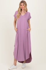 woman wearing a lavender short sleeve maxi dress with pockets and side slits, paired with white sneakers