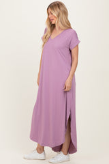 woman wearing a pastel purple short sleeve maxi dress with a v-neck and side slits, styled with white sneakers