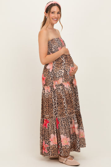 woman wearing a strapless leopard print maxi dress with floral details and holding her baby bump