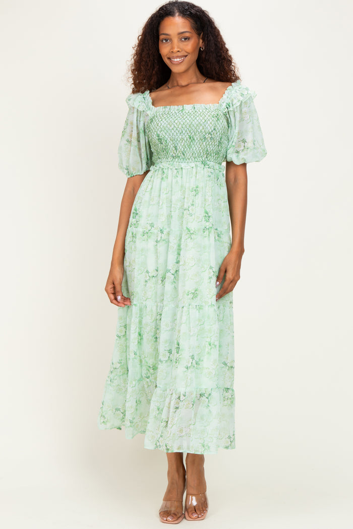 woman wearing a green floral maxi dress with short puff sleeves and smocked bodice