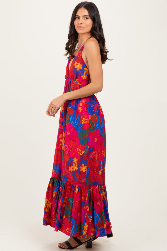 woman wearing a colorful floral maxi dress with a flared hem and spaghetti straps