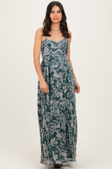 woman wearing a green floral maxi dress with a sweetheart neckline and flowing skirt