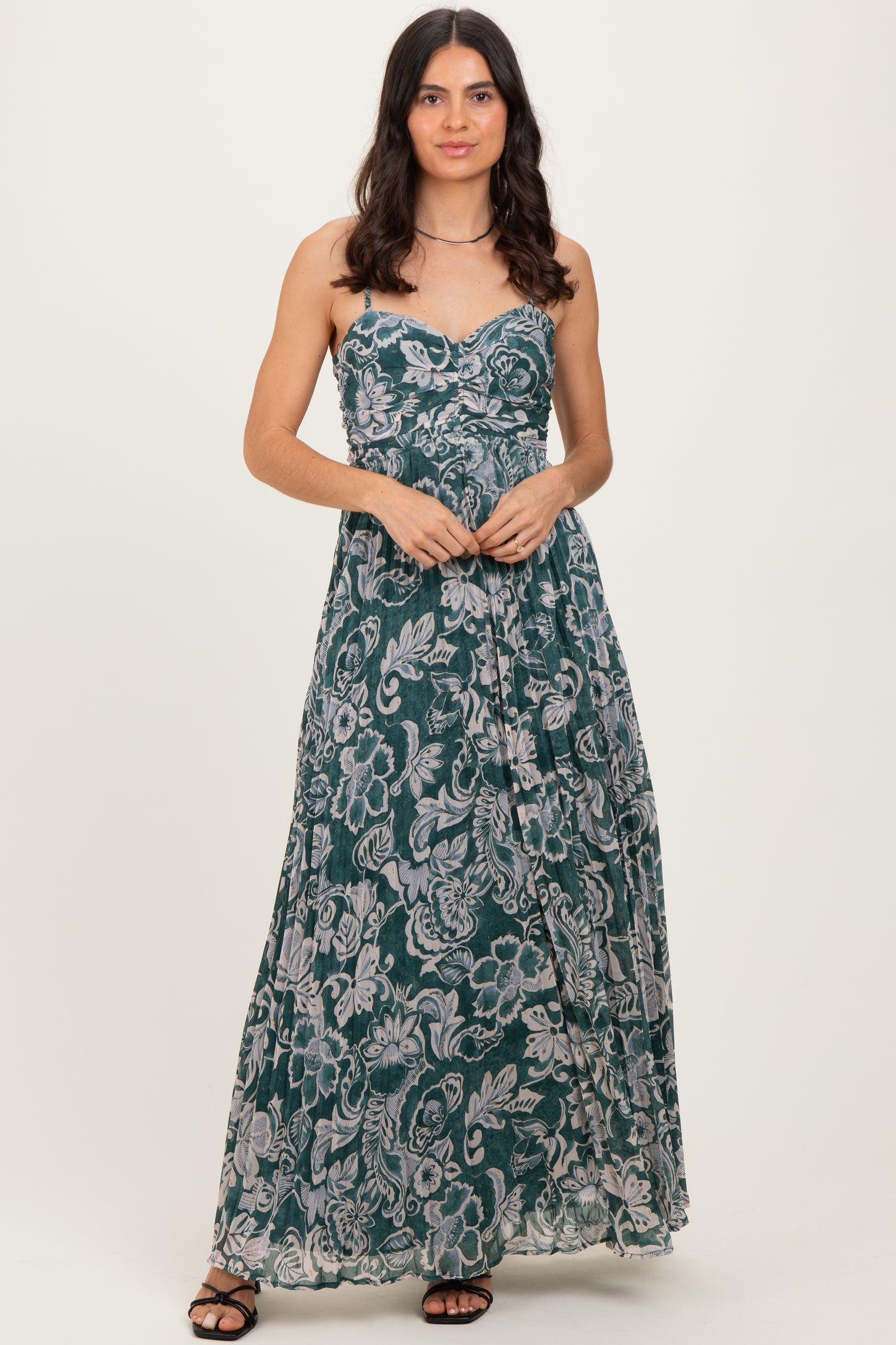woman wearing a green floral print maxi dress with a sweetheart neckline and adjustable straps