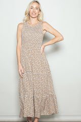woman wearing a sleeveless brown floral maxi dress with tiered ruffles and a relaxed fit