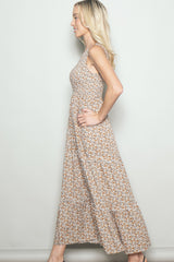 woman wearing a sleeveless floral maxi dress with a tiered skirt and a fitted bodice