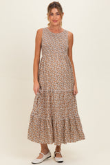 woman wearing a floral print sleeveless maxi maternity dress with a tiered skirt and a baby bump visible