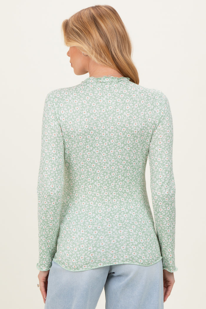 woman wearing a green floral long sleeve maternity top with a fitted style and rounded hem, showing the back view