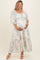 woman wearing a floral print long sleeve maternity dress and holding her baby bump