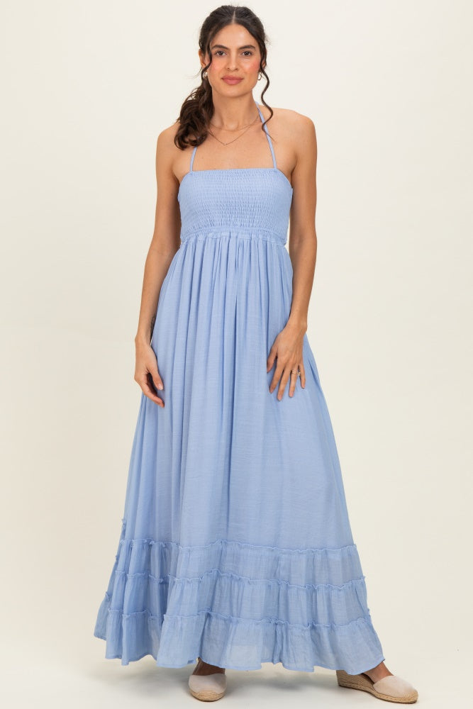 woman wearing a light blue strapless maxi dress with a smocked bodice and ruffle hem