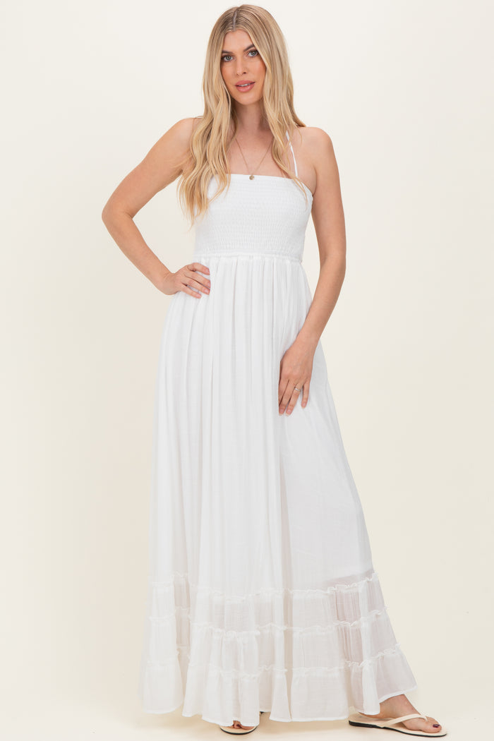 woman wearing a white maxi dress with a smocked bodice and tiered ruffle hem
