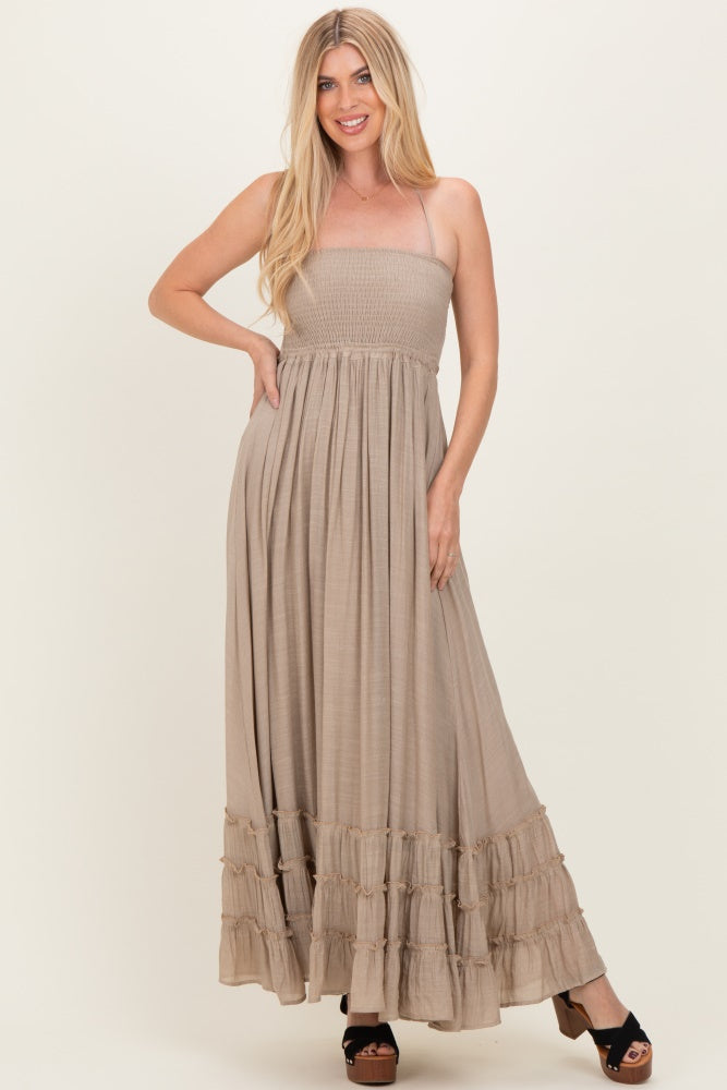 woman wearing a light brown strapless maxi dress with a smocked bodice and tiered ruffle hem