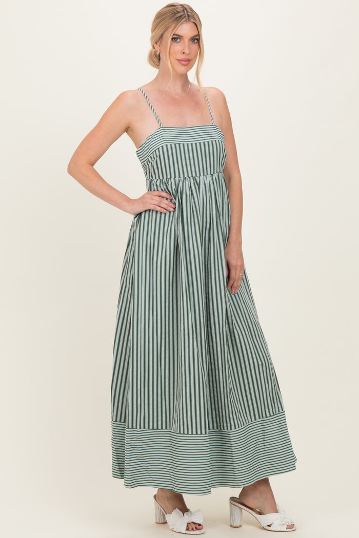 woman wearing a green and white striped maxi dress with thin straps and a fitted bodice