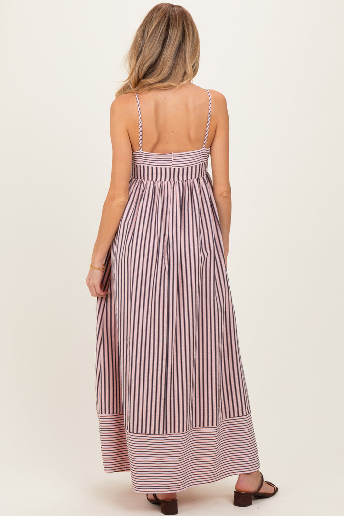 woman wearing a striped back view of a maternity maxi dress with thin straps and a flowing silhouette