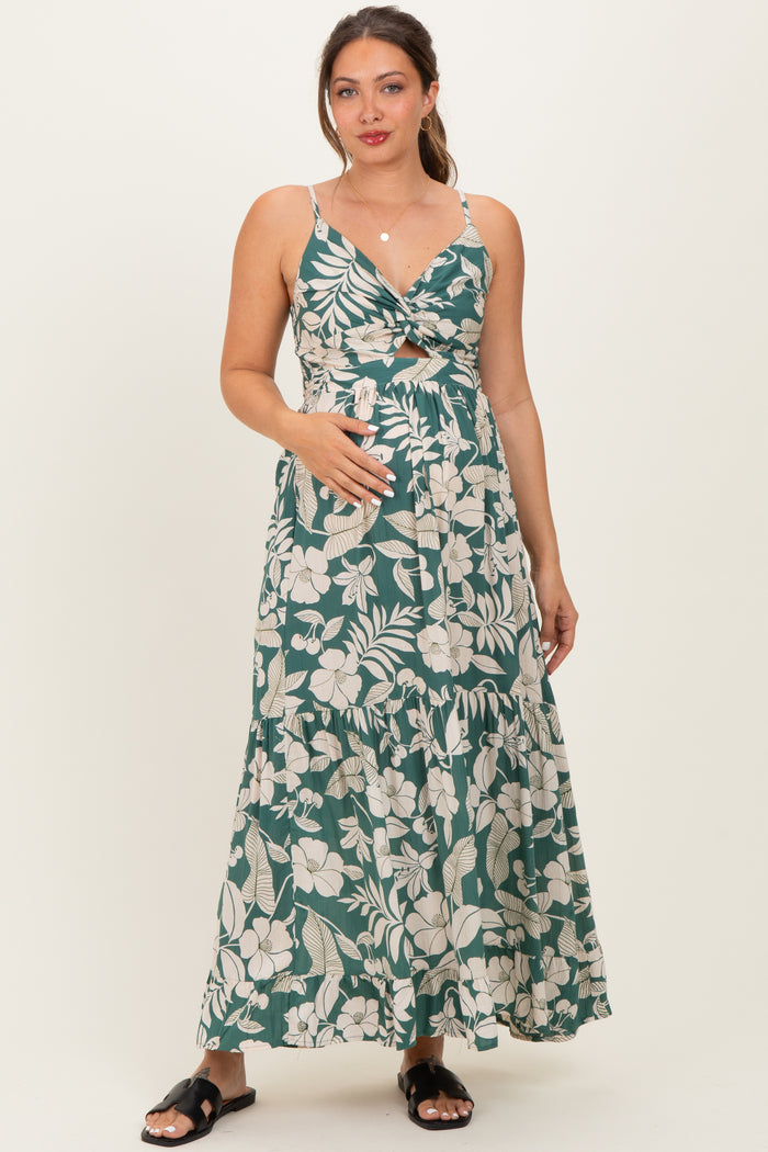 woman wearing a green floral maternity maxi dress with spaghetti straps and a baby bump