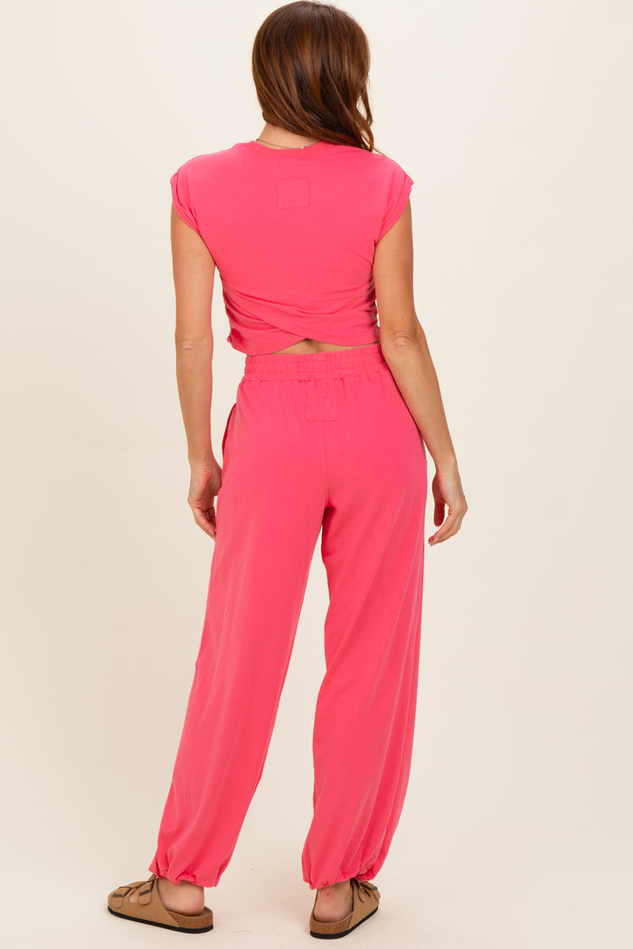 woman wearing a pink cropped top and matching loose-fitting pants, seen from the back
