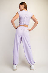 woman wearing a lavender cropped top and matching wide-leg pants, viewed from the back