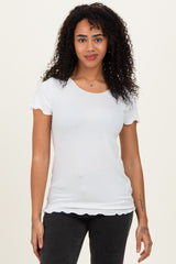 woman wearing a white short sleeve top with scalloped edges and a fitted style