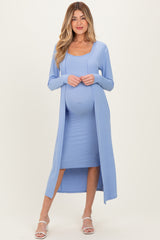 woman wearing a light blue maternity dress with a matching long cardigan and a visible baby bump