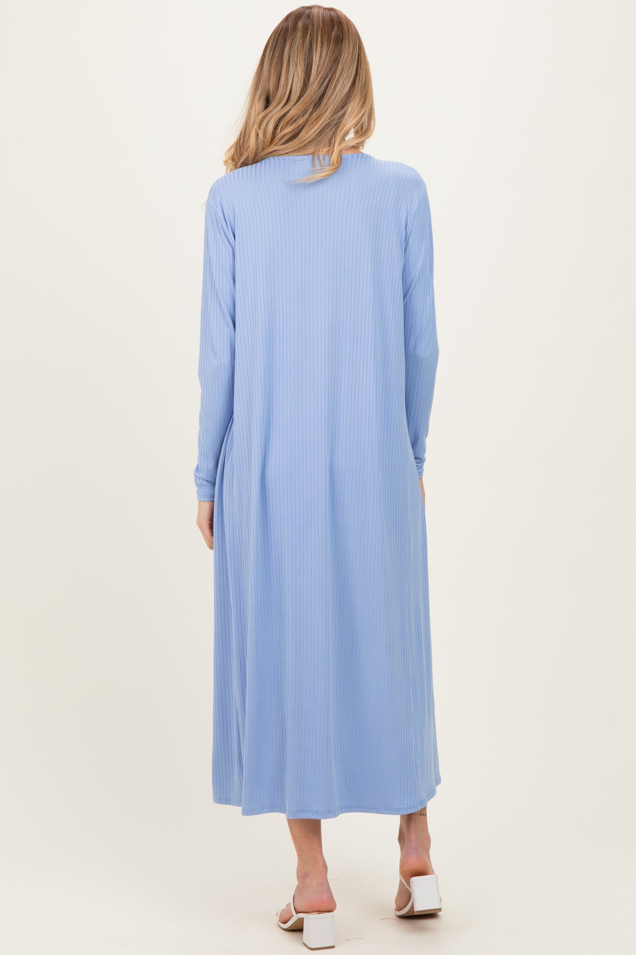 woman wearing a light blue long sleeve maternity maxi dress, shown from the back with a flowing silhouette