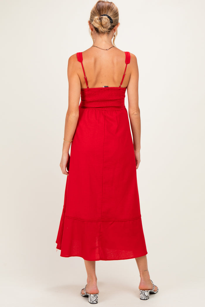 woman wearing a red maternity maxi dress with smocked bodice and adjustable straps, showing a baby bump