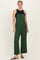 woman wearing a green wide-leg jumpsuit over a black tank top and flip flops