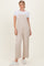 woman wearing a beige wide-leg jumpsuit over a white t-shirt with white sneakers