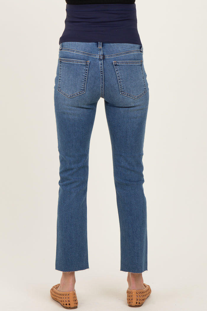 woman wearing a pair of blue maternity jeans with a straight leg and frayed hem, viewed from the back.