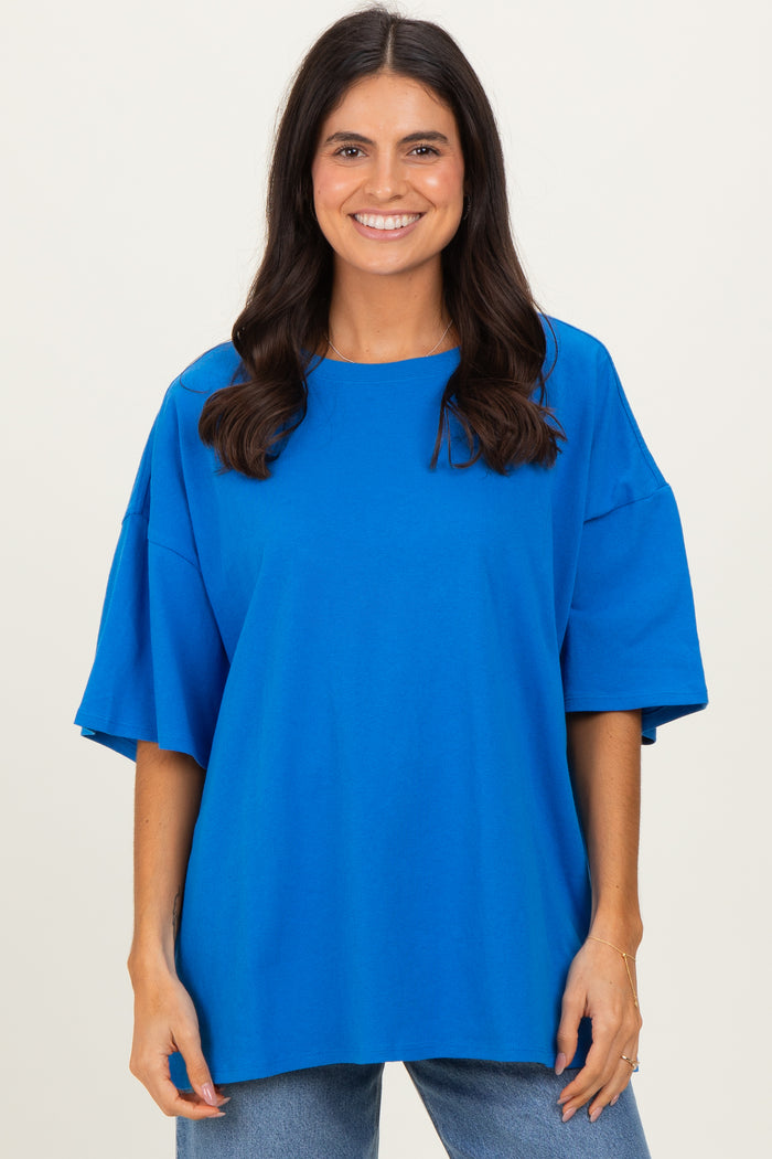 woman wearing a bright blue oversized t-shirt with wide sleeves and a relaxed fit