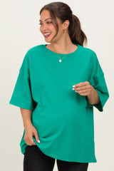 woman wearing a bright green oversized maternity t-shirt and showing her baby bump