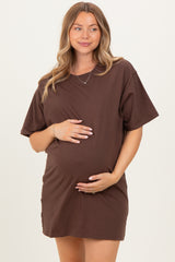 woman wearing a chocolate brown short sleeve maternity dress and holding her baby bump