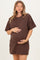 woman wearing a chocolate brown short sleeve maternity dress and holding her baby bump