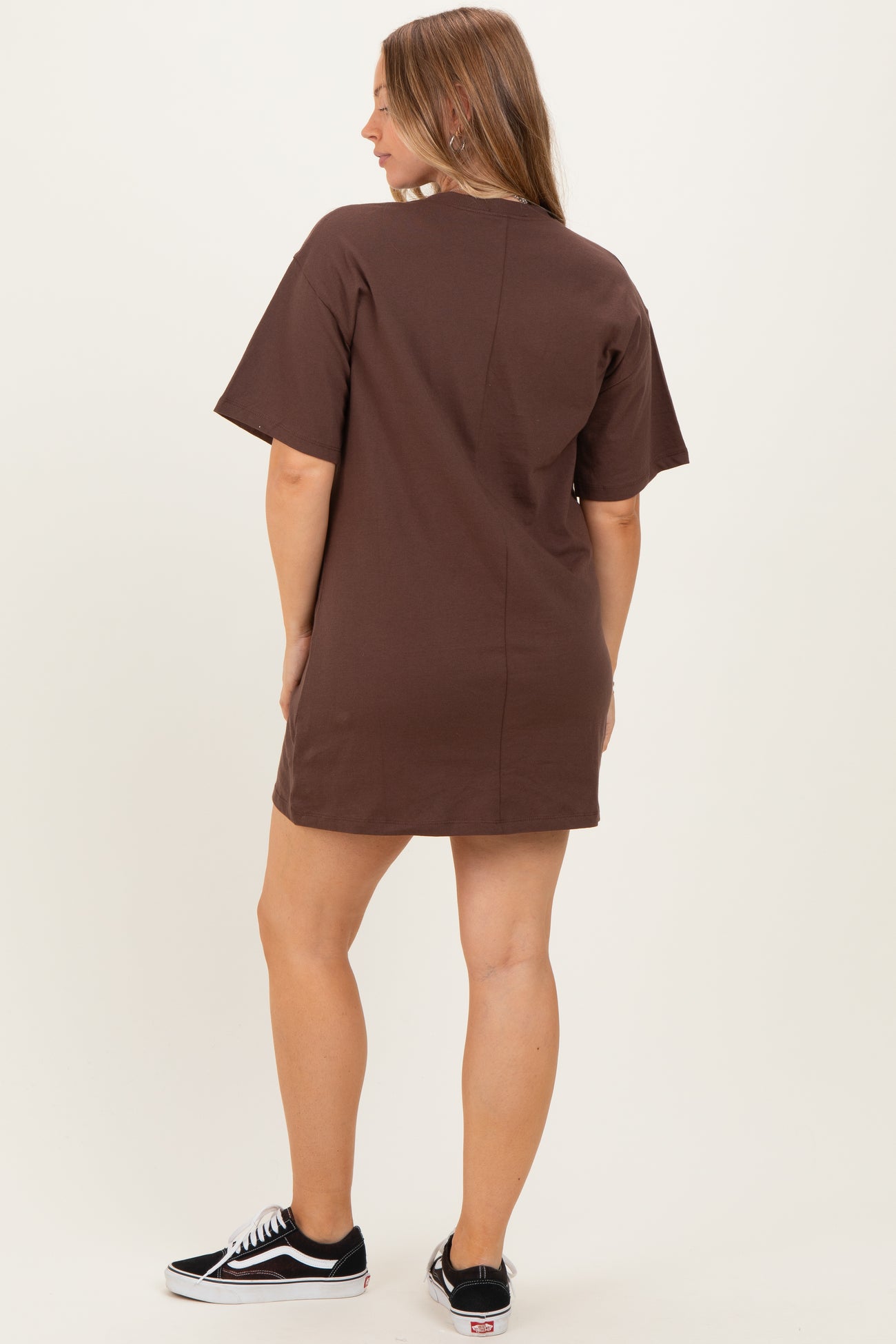 woman wearing a brown maternity t-shirt dress, standing with her back to the camera