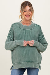 woman wearing a green striped oversized maternity sweater with a relaxed fit and ribbed details