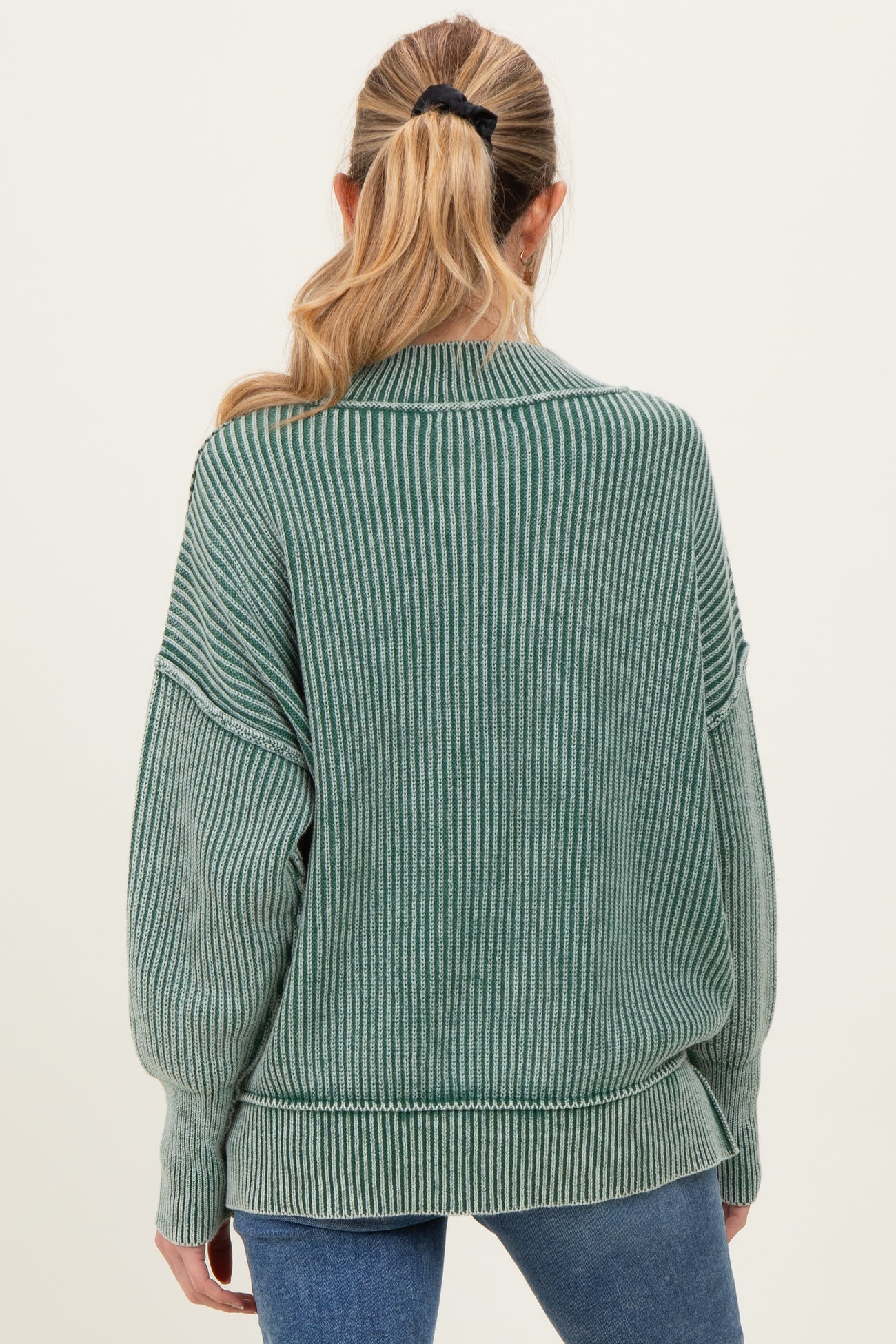 woman wearing a green ribbed oversized maternity sweater with a relaxed fit and long sleeves