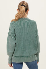 woman wearing a green ribbed oversized maternity sweater with a relaxed fit and long sleeves