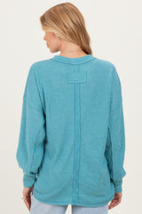 woman wearing a turquoise ribbed maternity top with long sleeves and a relaxed fit, seen from the back