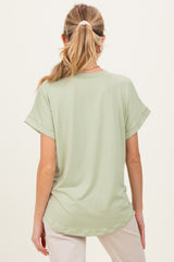 woman wearing a light green short sleeve maternity top, seen from the back